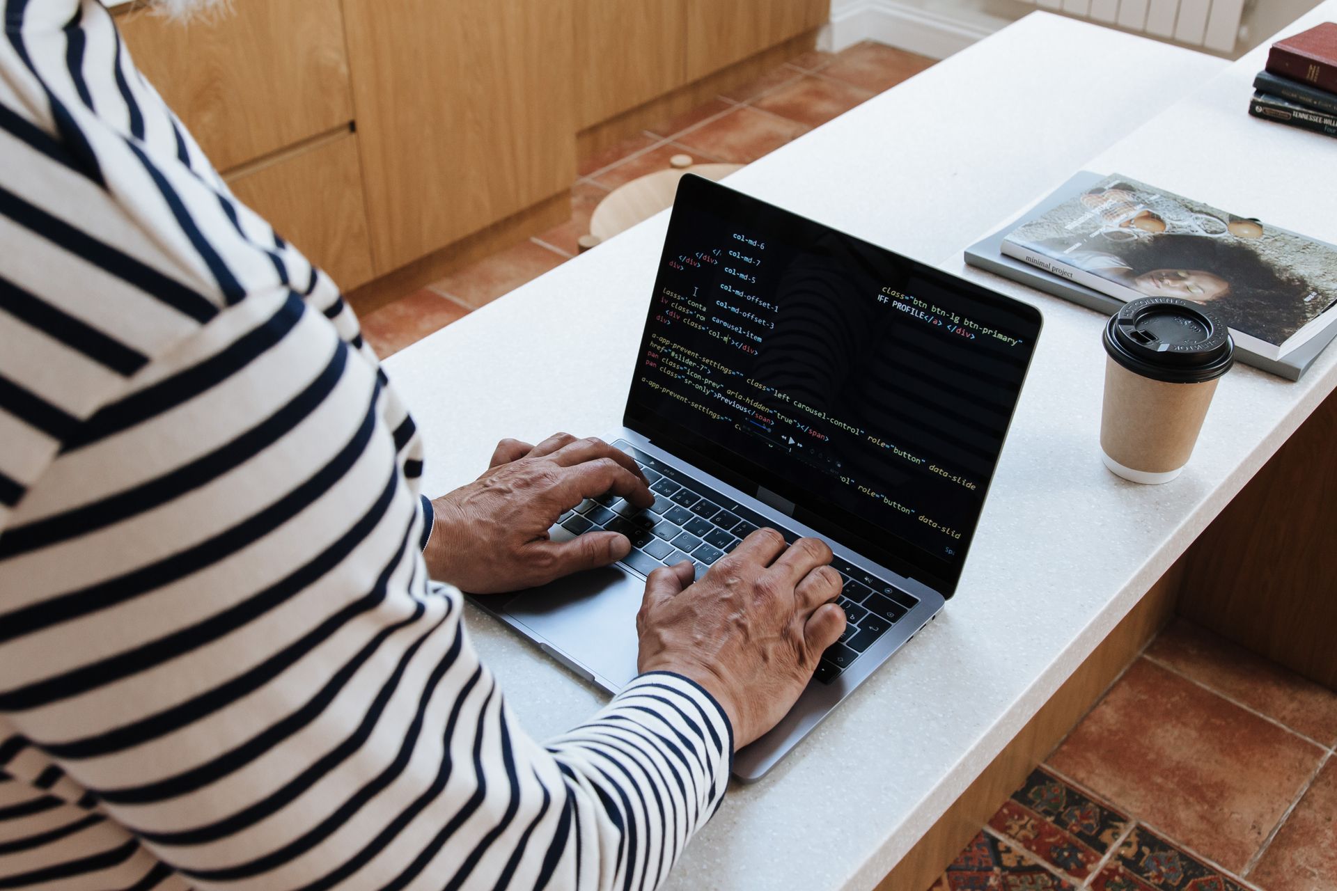 Person coding laptop focused